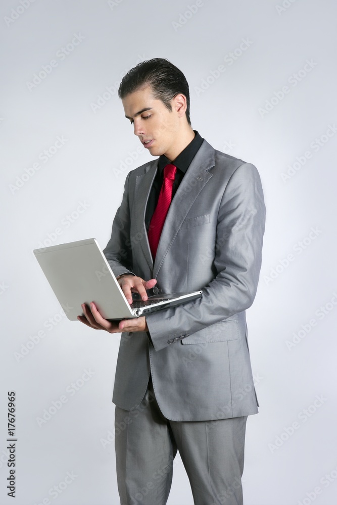 Businessman in gray suit holding laptop Businessman in gray suit holding laptop