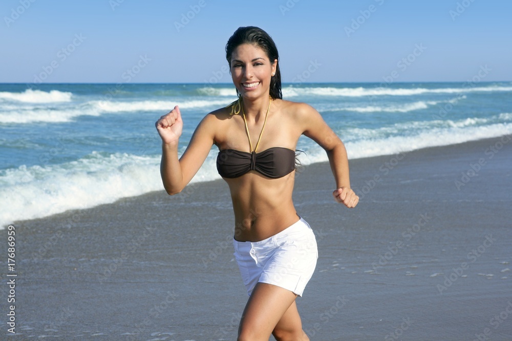 Beautiful summer brunette girl jumping on the beach Beautiful summer brunette girl jumping on the beach
