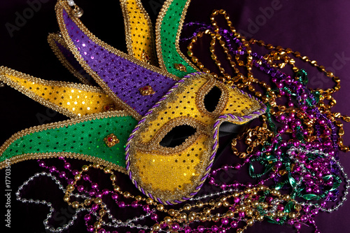 Mardi gra mask and beads on a purple background