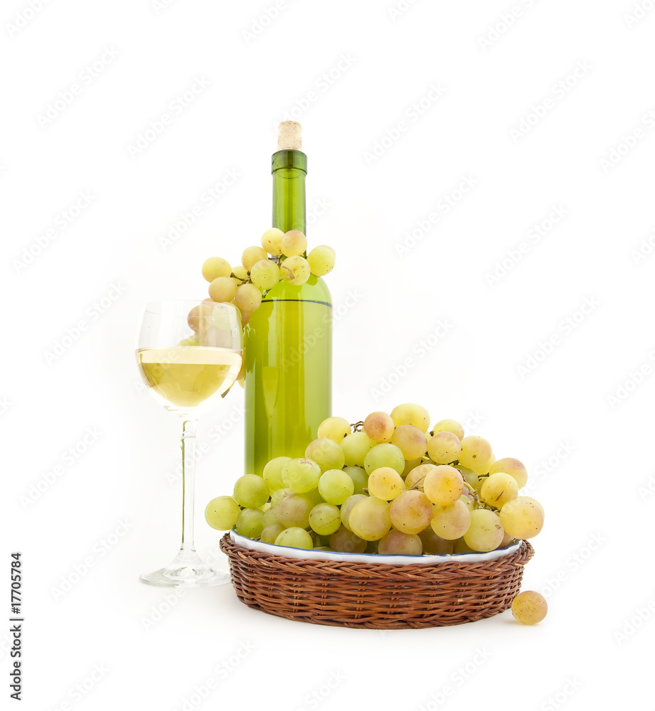 Bottle of white wine and white grapes on a dish