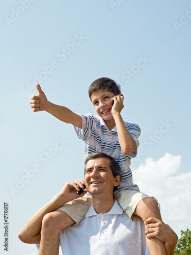 father and his son are speaking over mobiles