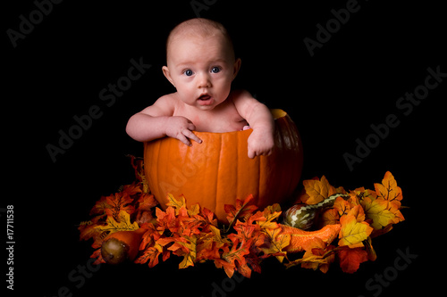 Baby in Large Pumpkin Isolated on Black