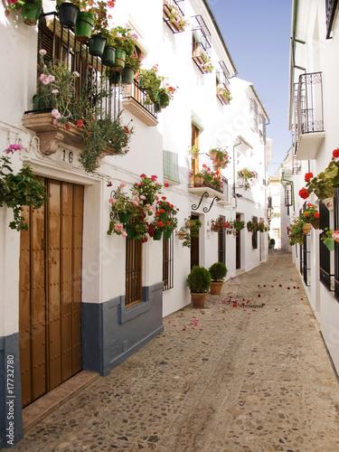 Canvas Print White washed cottages with windowbox flowers Spain