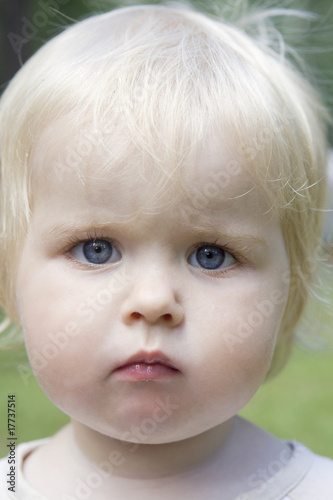 portrait of little cute blond serious baby girl
