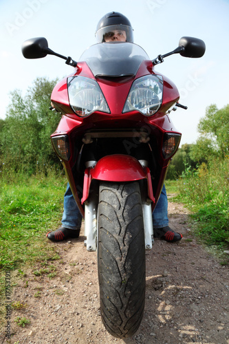 motorcyclist standing on country road, closeup, front view