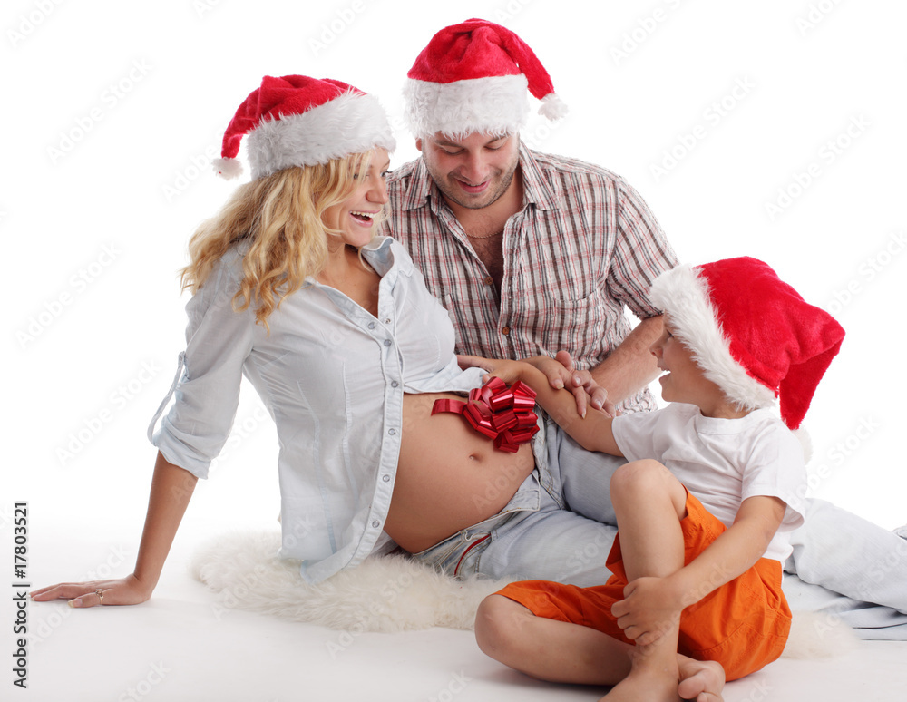 Obraz premium Father, son and pregnant mother in christmas hat