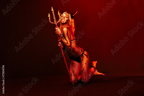 Beautiful devil with trident and Halloween accessories