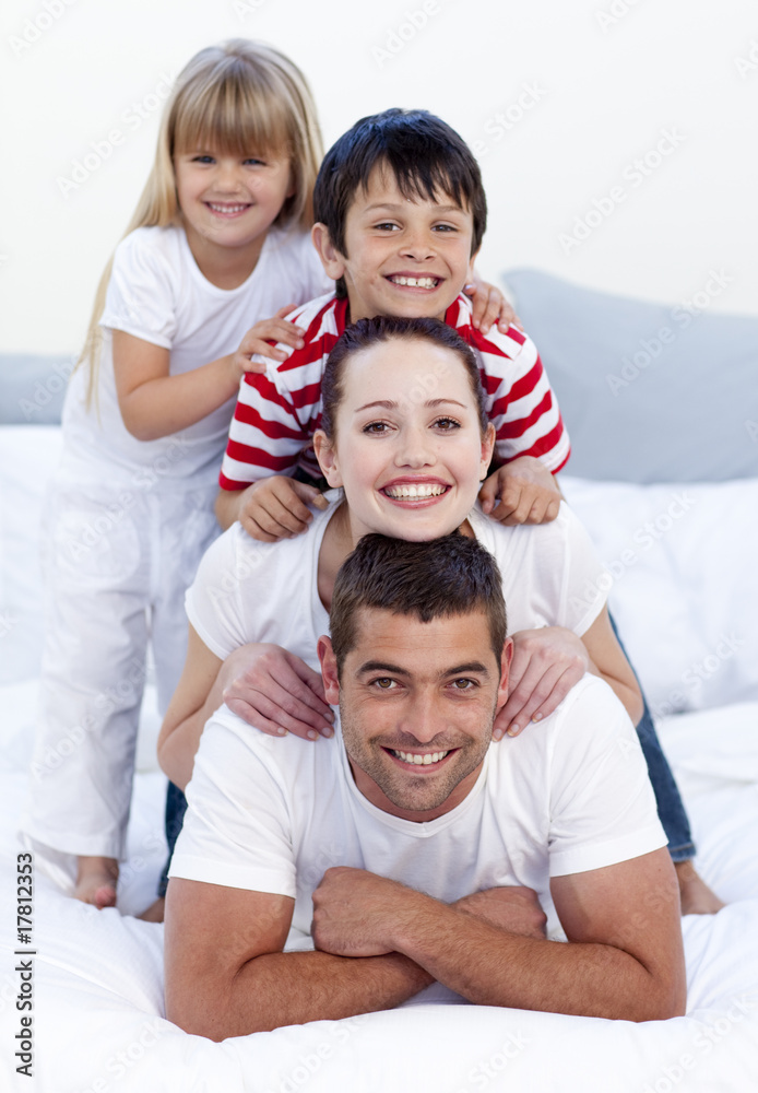 Happy family playing in bed together Happy family playing in bed together