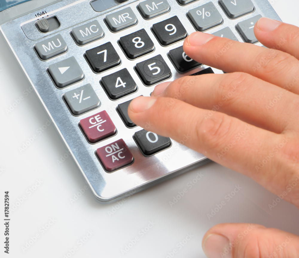 The calculator and a hand of the man The calculator and a hand of the man