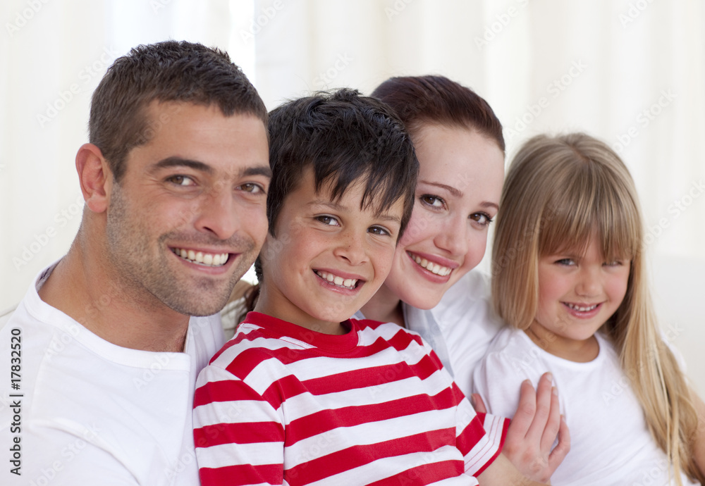 Portrait of parents, daughter and son sitting on sofa together Portrait of parents, daughter and son sitting on sofa together