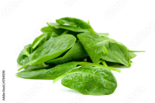 stacked fresh spinach over white backround