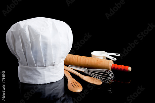 A chef's toque with cooking utensils photo