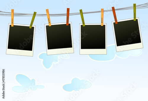Blank photographs on a rope against blue sky background