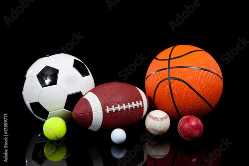 Assorted sports balls on a black background