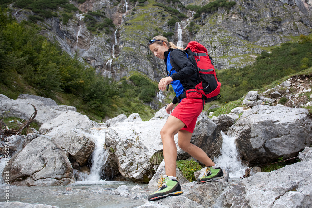 young woman trying to cross mountain stream young woman trying to cross mountain stream