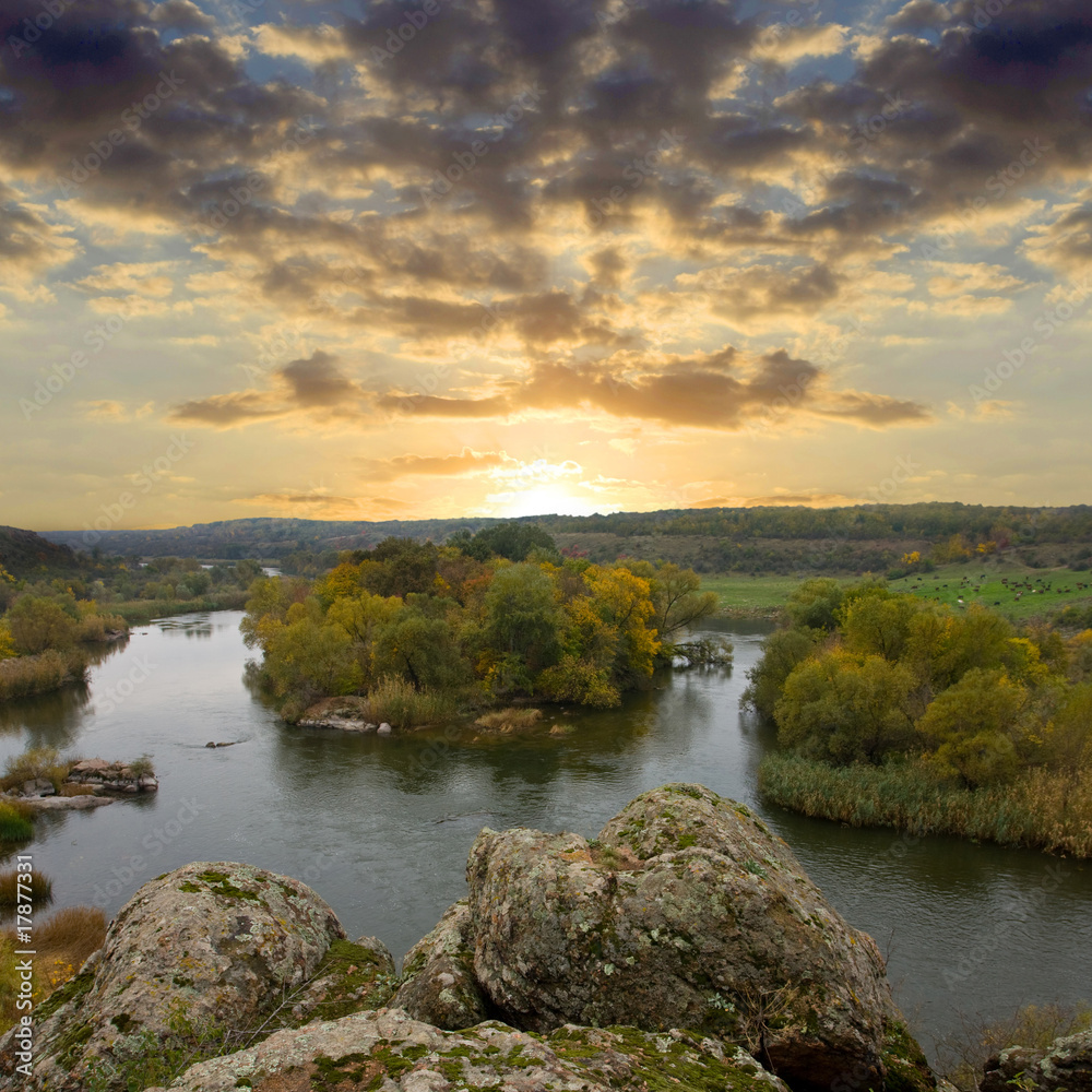 Naklejka premium Rock over river at sunset time