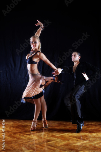 dancers in ballroom against black background