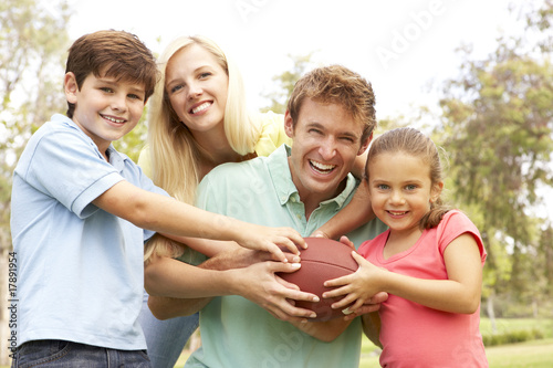 Family Playing American Football Together In Park © Monkey Business