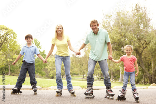 Family Wearing In Line Skates In Park