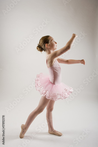 young girl practicing ballet dressed in pink tutu