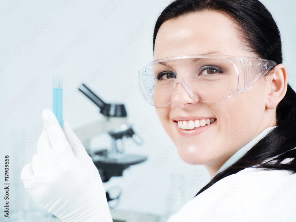 closeup of smiling female researcher holding test tube in labora closeup of smiling female researcher holding test tube in labora