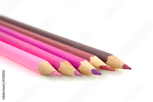 Pink and purple pencils over white background