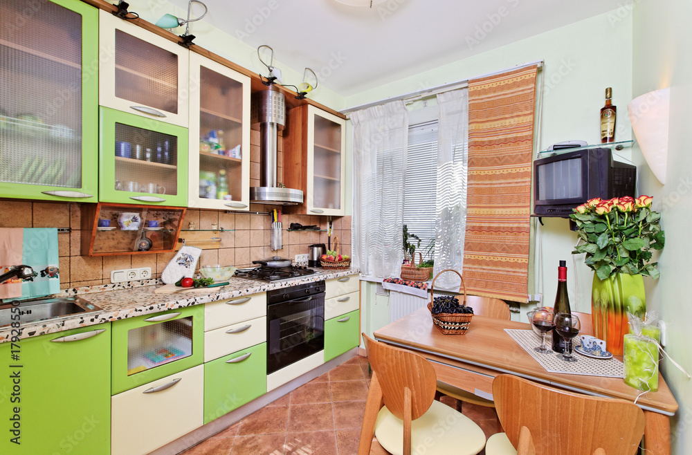 Green Kitchen interior with many utensils and window