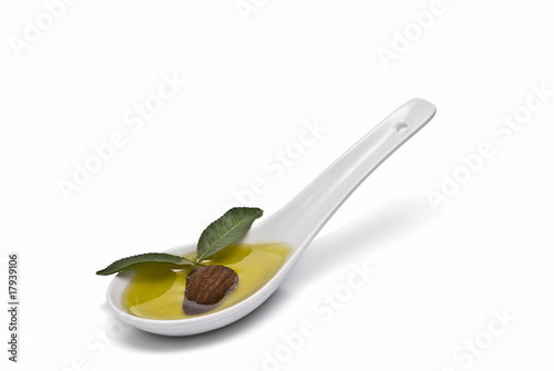 Almendra y hojas de almendro en cuchara de aceite.