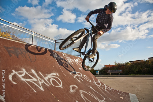 Photographie Jugendlicher springt an der Halfpipe mit dem Dirtbike