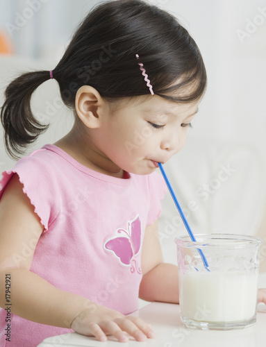 Mixed race girl drinking milk with straw photo