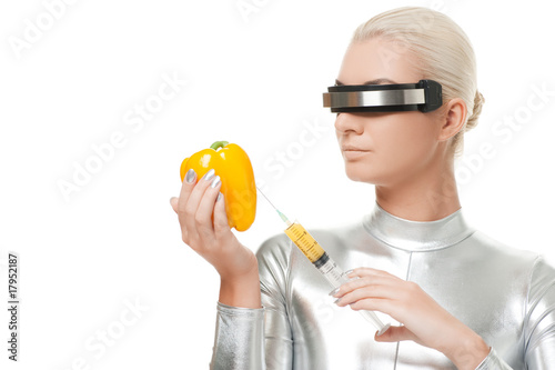 Cyber woman taking vitamins from sweet pepper photo