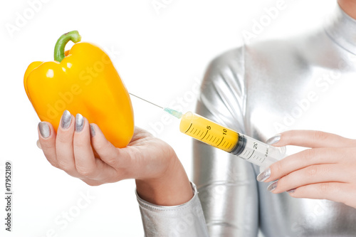 Cyber woman taking vitamins from sweet pepper photo