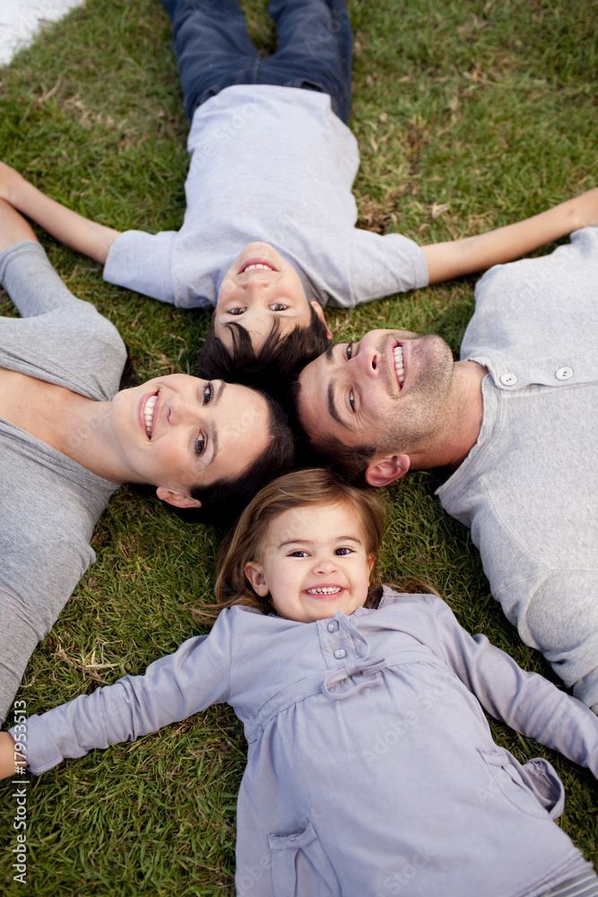 Family lying in a garden with heads together Family lying in a garden with heads together