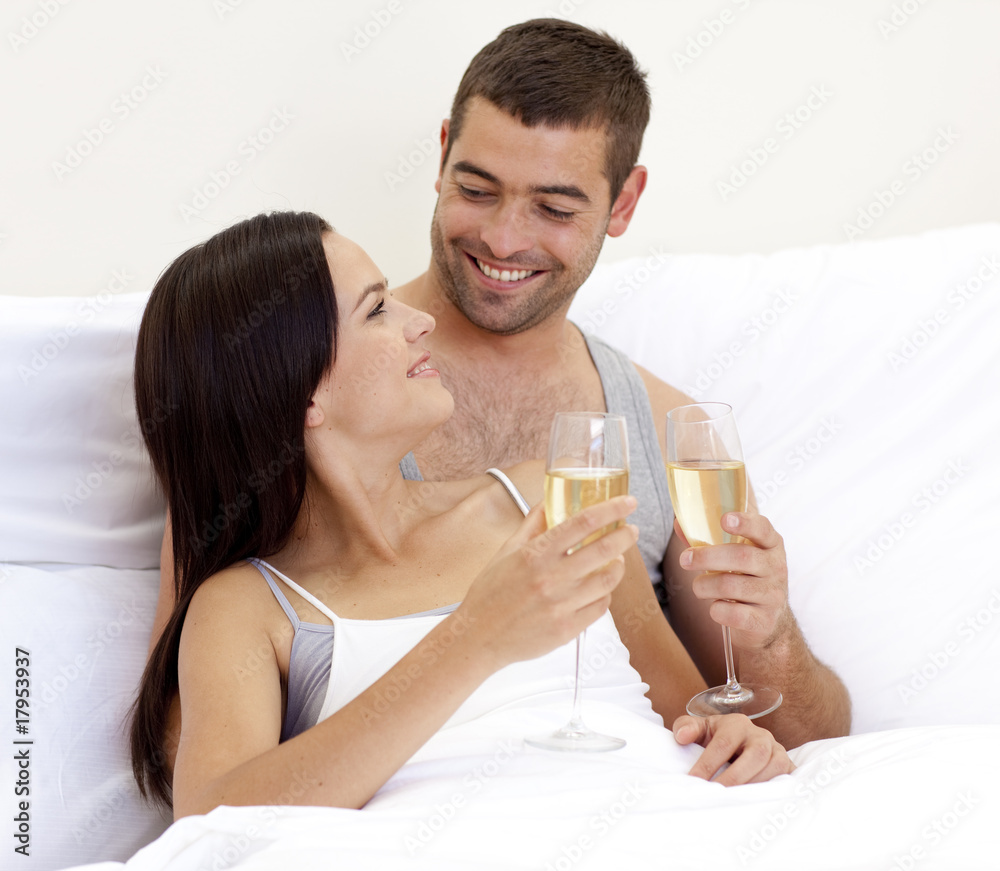 Couple drinking champagne in bed Couple drinking champagne in bed