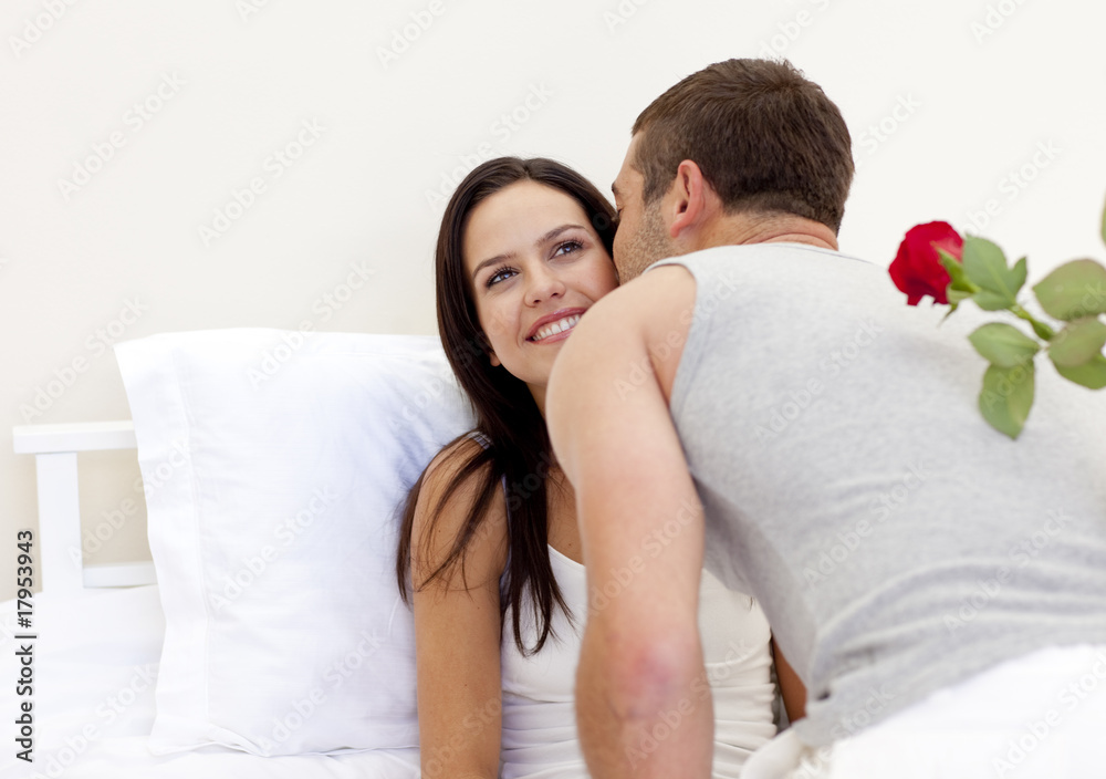 Man holding a rose giving a kiss to his beautiful wife Man holding a rose giving a kiss to his beautiful wife