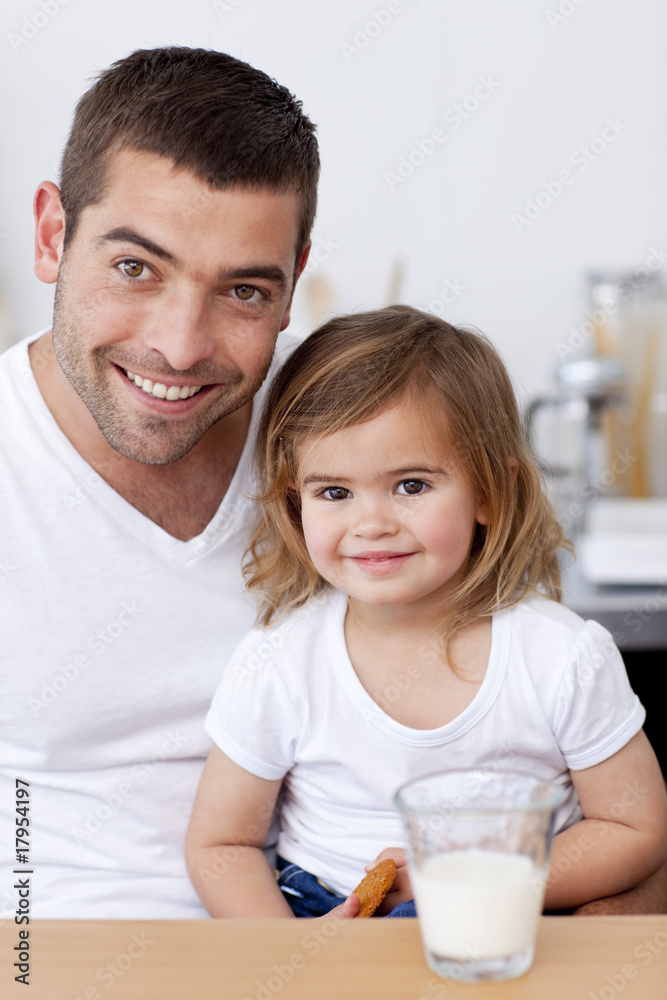 Smiling dad and little girl eating biscuits with milk Smiling dad and little girl eating biscuits with milk