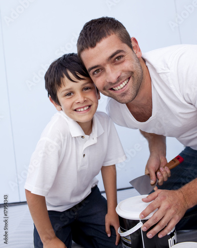 Smiling father and son painting a bedroom
