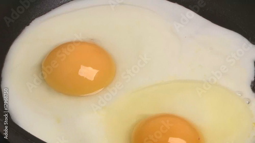 Fried eggs preparation on a frying pan, timelapse.