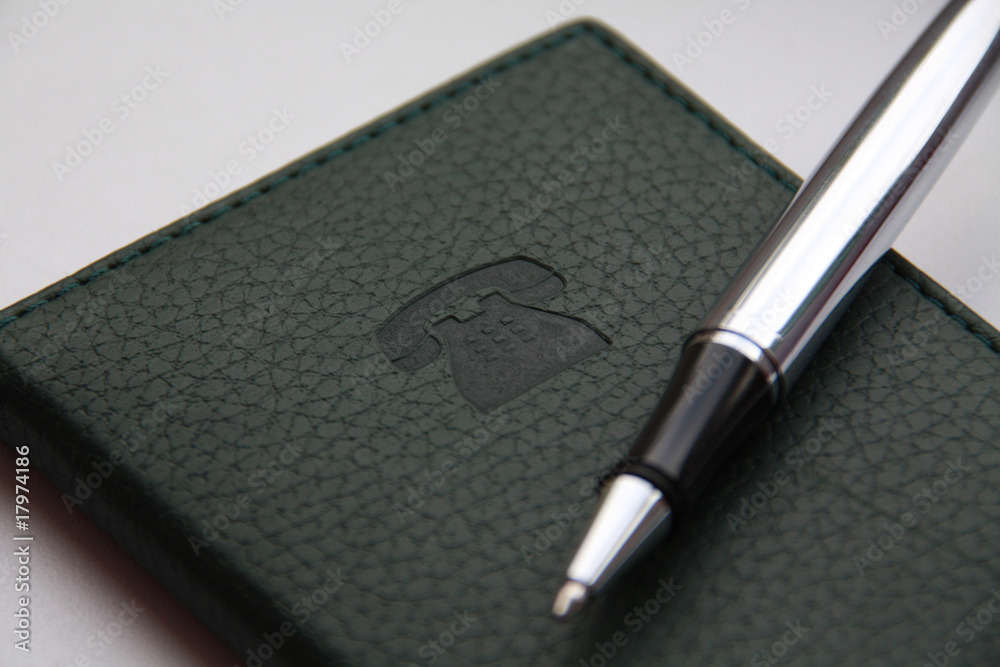Green notebook with stamping sign of the telephone and ball-poin Green notebook with stamping sign of the telephone and ball-poin