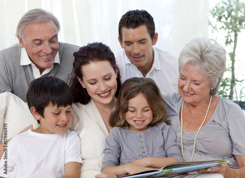 Family sitting on sofa reading a book Family sitting on sofa reading a book