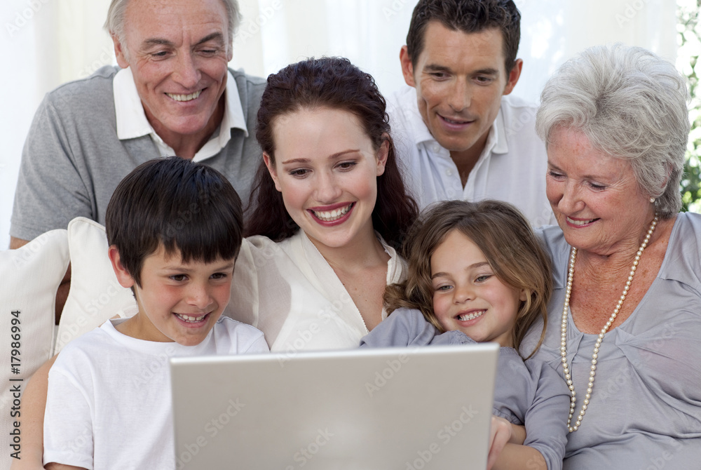 Family sitting on sofa using a laptop Family sitting on sofa using a laptop