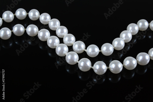 pearl necklace on a dark background with reflection