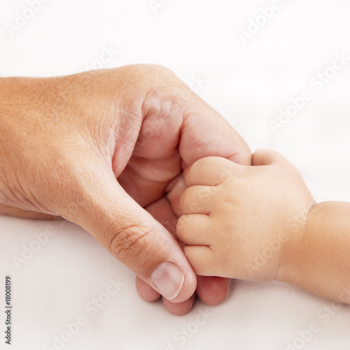 Baby holding dads hand