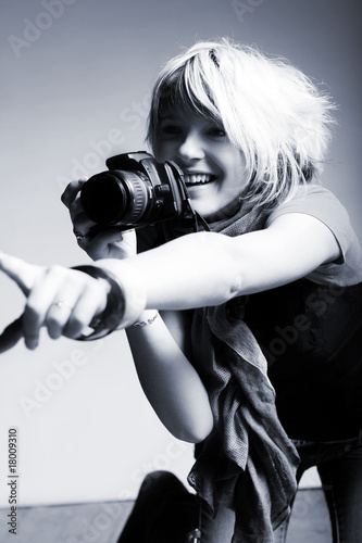 Young beautiful woman taking a photo with a digital camera