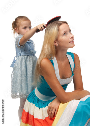 Girl brushes hair of mum.