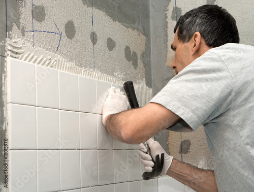 Man Tiling A Bathroom Wall