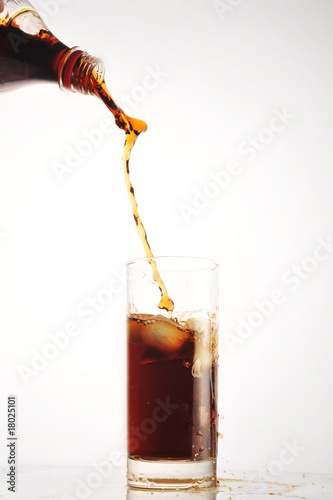 cola pour into glass on white