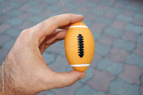 American football ball in hand