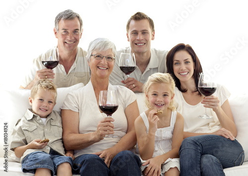 Family in living-room drinking wine and eating biscuits