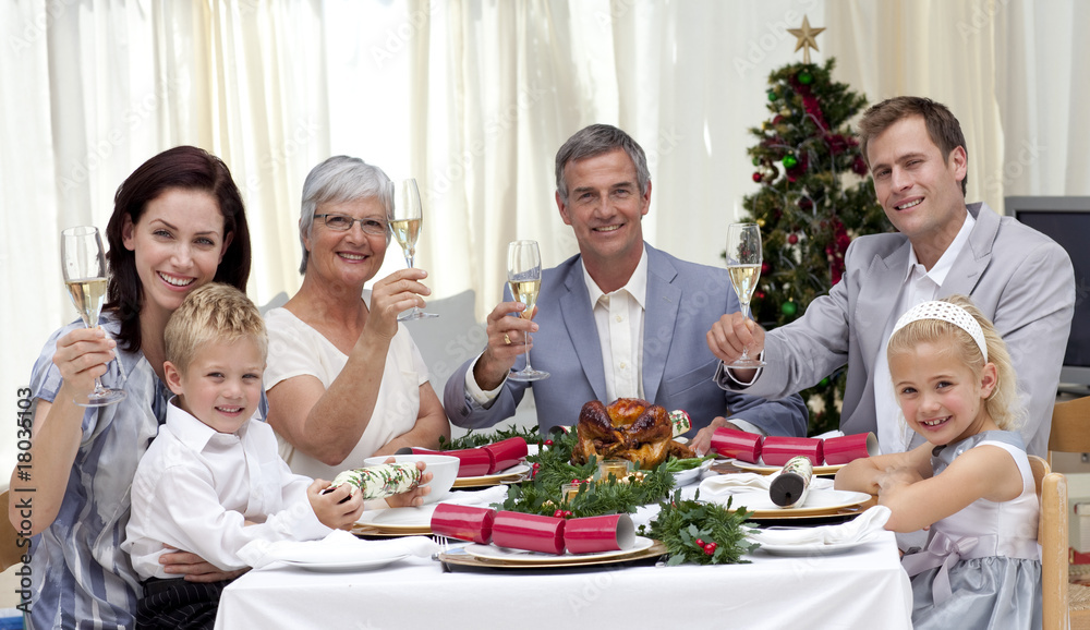 Family tusting in a Christmas dinner with white wine